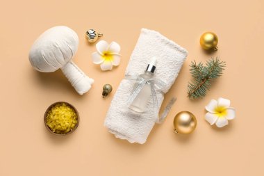 Renk arkaplanı üzerine spa aksesuarları ve Noel süslemeleri içeren kompozisyon