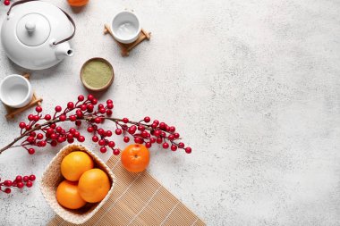 Çayla demlenmiş çaydanlık, beyaz grunge arka planda mandalina ve böğürtlen. Yeni yıl kutlaması