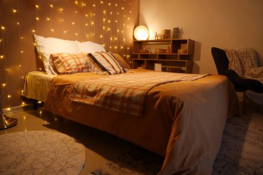 Geceleri parlayan ışıklar ve lambayla dolu yatak odasının içi.