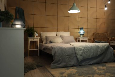 Geceleri parıldayan lambalar ve masaları olan şık bir yatak odası.