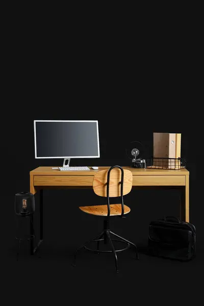 Stylish workplace with modern computer on dark background