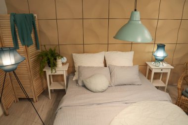 Geceleri parıldayan lambalar ve masaları olan şık bir yatak odası.