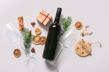 Bir şişe şarap ve beyaz arka planda Noel hediyesi kutusu.