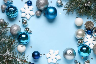 Mavi arka planda Noel toplarından ve köknar dallarından yapılmış çerçeve