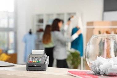 Ödeme terminali giyim mağazasında tezgahın üzerinde, yakın plan.