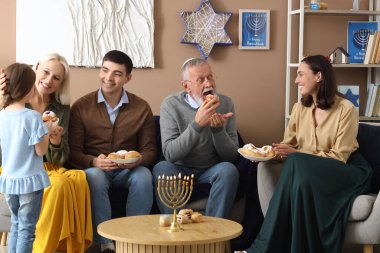 Hanuka bayramını evde donutlarıyla kutlayan mutlu Yahudi bir aile.