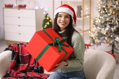 Noel Baba şapkalı güzel genç bir kadın evde Noel hediyesiyle