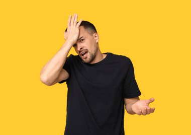 Yakışıklı, utangaç, sarı arka planda yüzü olan genç bir adam.