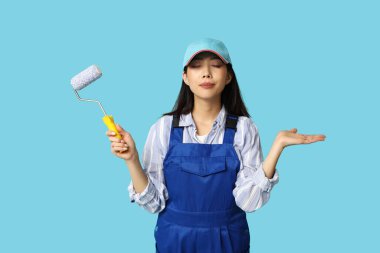 Mavi arka planda yuvarlanan Asyalı kadın ressam