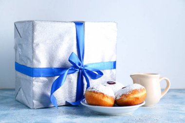 Lezzetli çörekler, süt ve Hanuka kutlaması için renkli masalarda hediyeler.