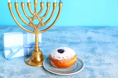 Lezzetli çörek, menorah ve Hanuka kutlaması için renk masasında hediye.