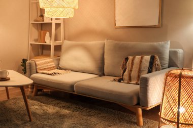 Gri kanepesi, sehpası ve gece lambasıyla modern oturma odasının içinde.