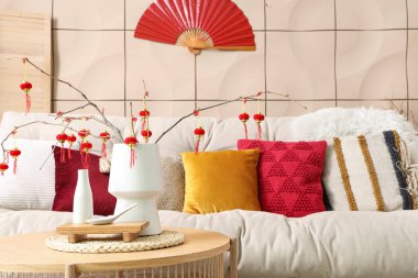 Oturma odasındaki sehpanın üzerinde ağaç dalları ve geleneksel Çin fenerleri olan vazo. Çin Yeni Yıl Kutlaması