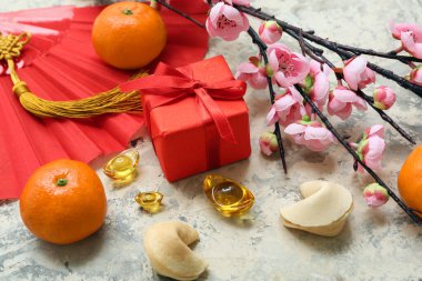 Şans kurabiyeleri, mandalina ve arkaplanda Çince semboller olan bir hediye kutusu. Yeni yıl kutlaması