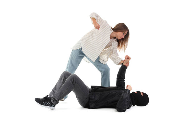 Woman defending herself against robber on white background