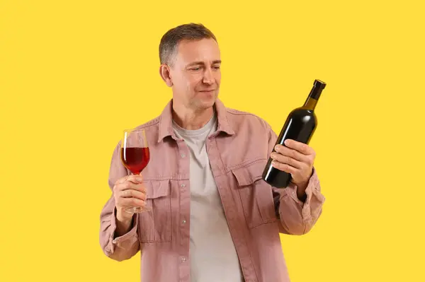 Reifer Mann Mit Glas Und Flasche Rotwein Auf Gelbem Hintergrund — Stockfoto