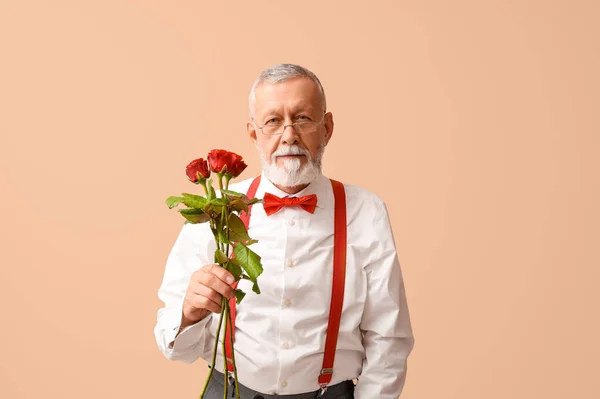 Mature man with rose flowers on beige background. Valentine\'s day celebration