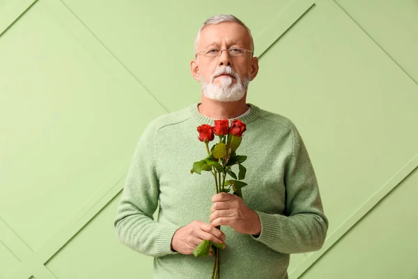 Mature man with rose flowers on green background. Valentine\'s day celebration