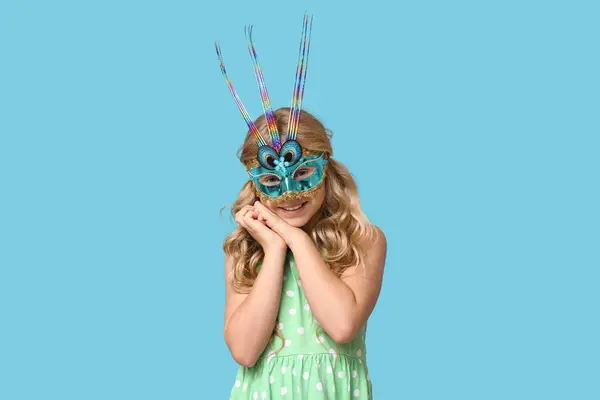Hübsches Kleines Mädchen Mit Karnevalsmaske Auf Blauem Hintergrund lizenzfreie Stockbilder