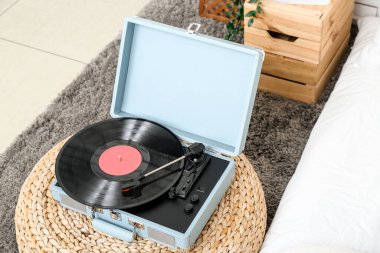 Yatak odasındaki pouf 'ta vinil diski olan kayıt çalar