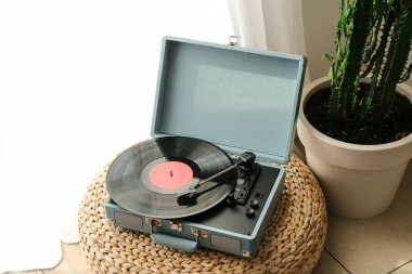 Odada pouf 'ta vinil diski olan kayıt çalar