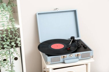 Oturma odasındaki rafta vinil diski olan kayıt çalar