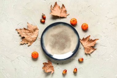 Kuru akçaağaç yaprakları, balkabakları ve yeşil arka planda meşe palamudu ile süslü sonbahar sofrası