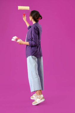 Renkli paletleri ve mor arka planı olan genç bir kadın.