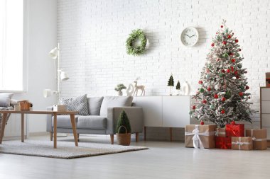 Güzel bir Noel ağacı ve hediyeleri olan şık bir oturma odası.