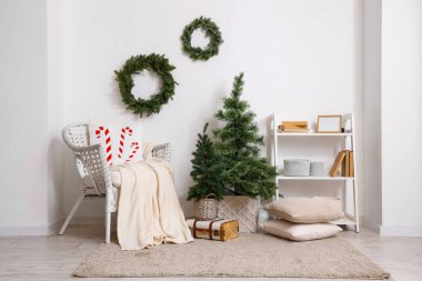 Noel ağaçları ve ökse otu çelenkleriyle modern oturma odasının şık bir iç mekanı.