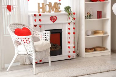 Sevgililer Günü kutlamaları için koltuğu, şöminesi ve süslemeleri olan şenlikli oturma odasının içinde.