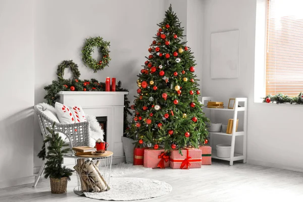 Stylish interior of light living room with beautiful Christmas tree and mistletoe wreathes