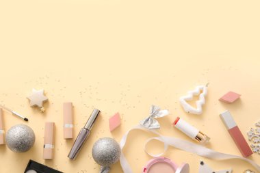 Bej arka planda dekoratif kozmetik ve gümüş Noel dekoru olan kompozisyon