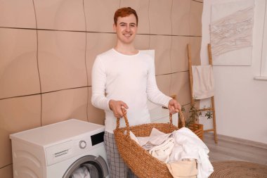 Çamaşır sepetli genç adam.