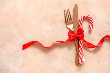 Çatal bıçak ve şeker kamışı bej renginde kırmızı kurdeleyle bağlanmış.