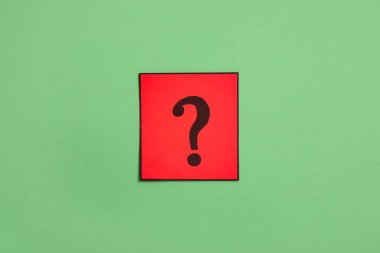 Yeşil arkaplanda soru işareti olan kağıt