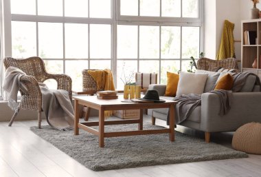 Gri kanepesi ve masası olan oturma odasının içinde.