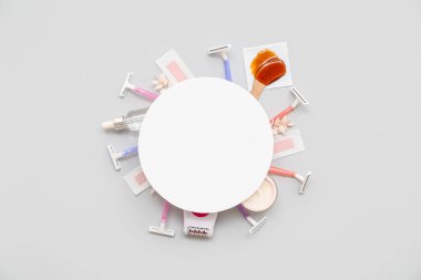 Gri arka planda saç çıkarmak için farklı malzemeler içeren boş kart.