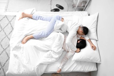 Yatak odasında uyuyan genç bir çift.