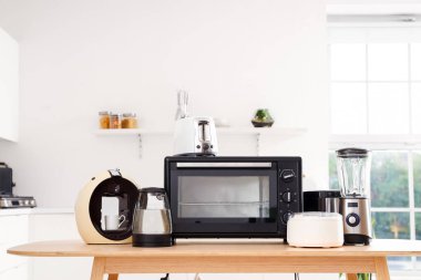 Hafif mutfakta modern aletler bulunan ahşap masa.