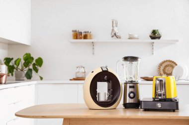 Hafif mutfakta modern aletler bulunan ahşap masa.