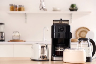 Hafif mutfakta modern aletler bulunan ahşap masa.