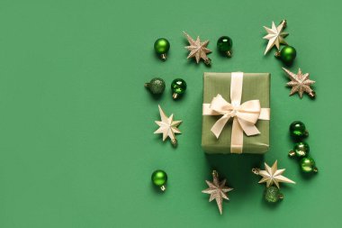 Yeşil arka planda hediye kutusu ve Noel topları