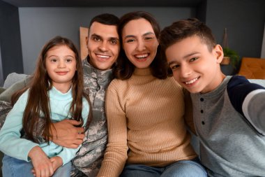 Karısı ve çocuklarıyla evde selfie çeken bir asker.
