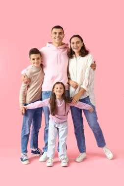 Pembe arka planda aileleri kucaklayan küçük çocuklar.
