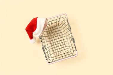 Arka planda Noel Baba şapkası olan alışveriş sepeti.