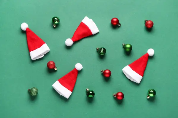 Noel Baba Şapkaları Noel Topları Yeşil Arka Planda — Stok fotoğraf