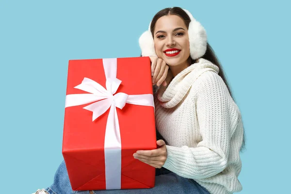 青の背景にクリスマスの贈り物を持つ美しい若い女性 — ストック写真