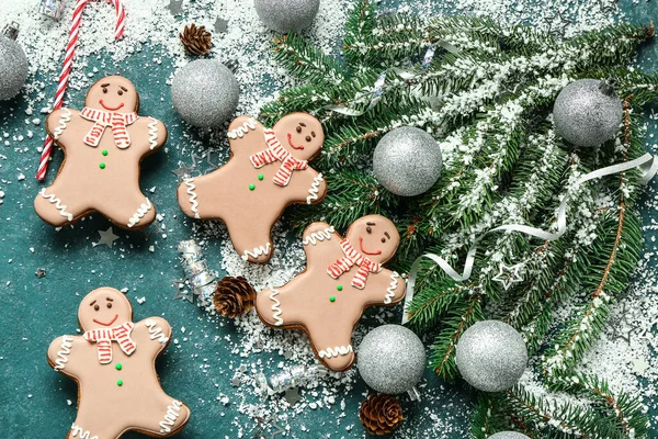Christmas sweet gingerbread cookies with candy cane and fir branches on green background
