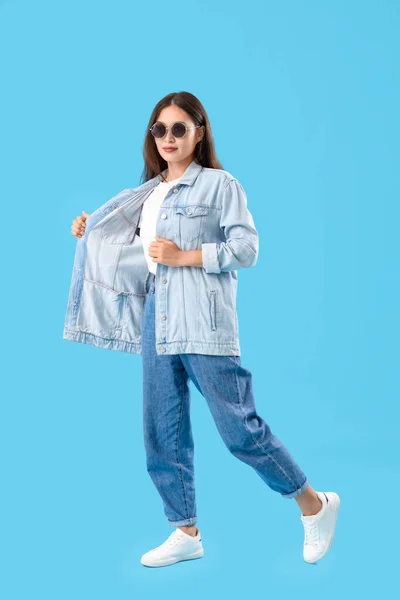 Stilvolle Junge Asiatin Sonnenbrille Und Jeanskleidung Auf Blauem Hintergrund — Stockfoto
